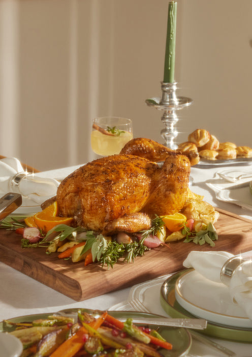 Cooked turkey set on walnut cutting board on table