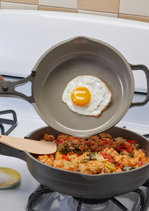 Transferring an egg from a black Mini Always Pan to a black Always Pan