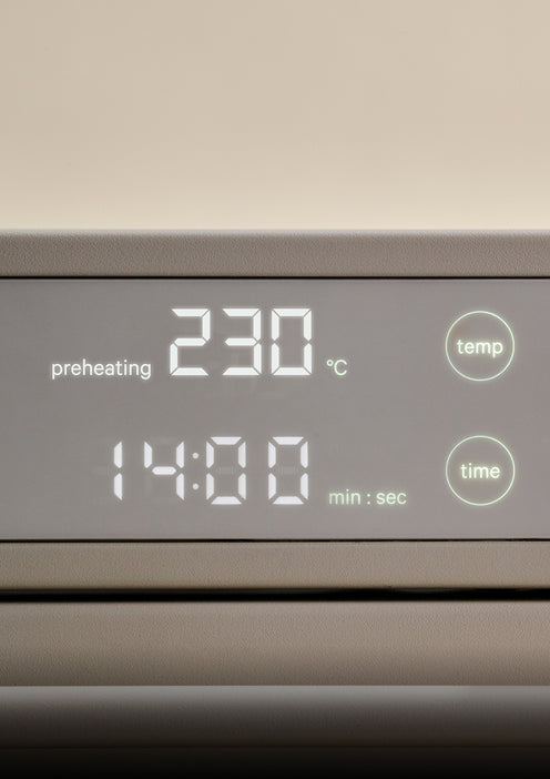 Digital oven display showing a temperature of 230 degrees Celsius, a time of 14:00, and a preheating indicator.