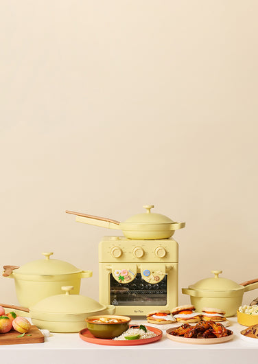 Collection of yellow kitchen appliances and food items on a beige background