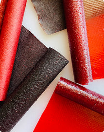 Close-up of red and black licorice sticks on a white background