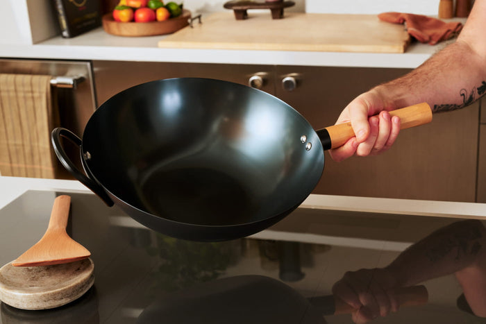 A hand holding a wok