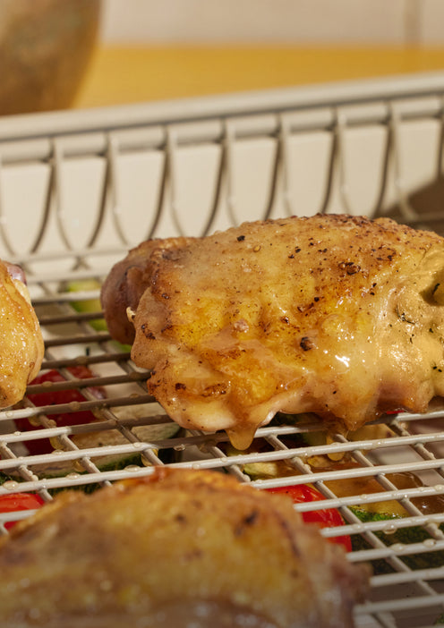 Chicken cooking on a beige Oven Rack