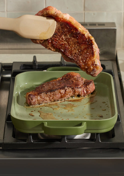 Searing steak on a green Mini Griddle Pan on the stove