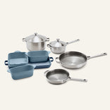 Titanium Pro Cookware + Bakeware Set 2.0 featuring high-performance stainless steel cookware, including two lidded pots and two skillets, alongside a set of blue ceramic bakeware.