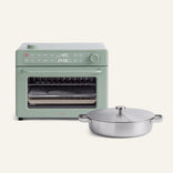 A Wonder Oven Pro in green with 8-in-1 functionality, digital controls, and a glass door sits behind a stainless steel lidded pot and a Titanium Braiser Pro, all set against a light background.