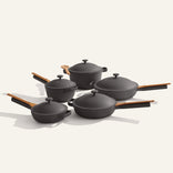Set of black cookware with wooden handles on a white background