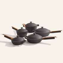 Set of black cookware with wooden handles on a white background