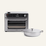 The Wonder Oven Pro, a stainless steel air-fryer oven with digital controls, is displayed beside the Titanium Braiser Pro with its lid, set against a plain background.