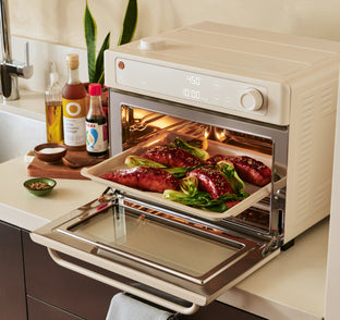 Kitchen scene with a toaster oven displaying food inside, on a kitchen counter.