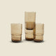 Set of three wooden tumblers on a beige background