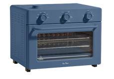 A blue countertop toaster oven with three control knobs on top, a glass door, wire racks inside, and sturdy black feet.