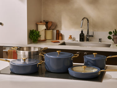 Blue cookware set on a stove with a kitchen background