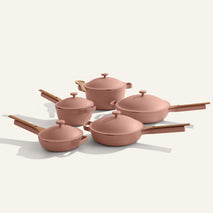 Set of pink cookware with lids on a white background